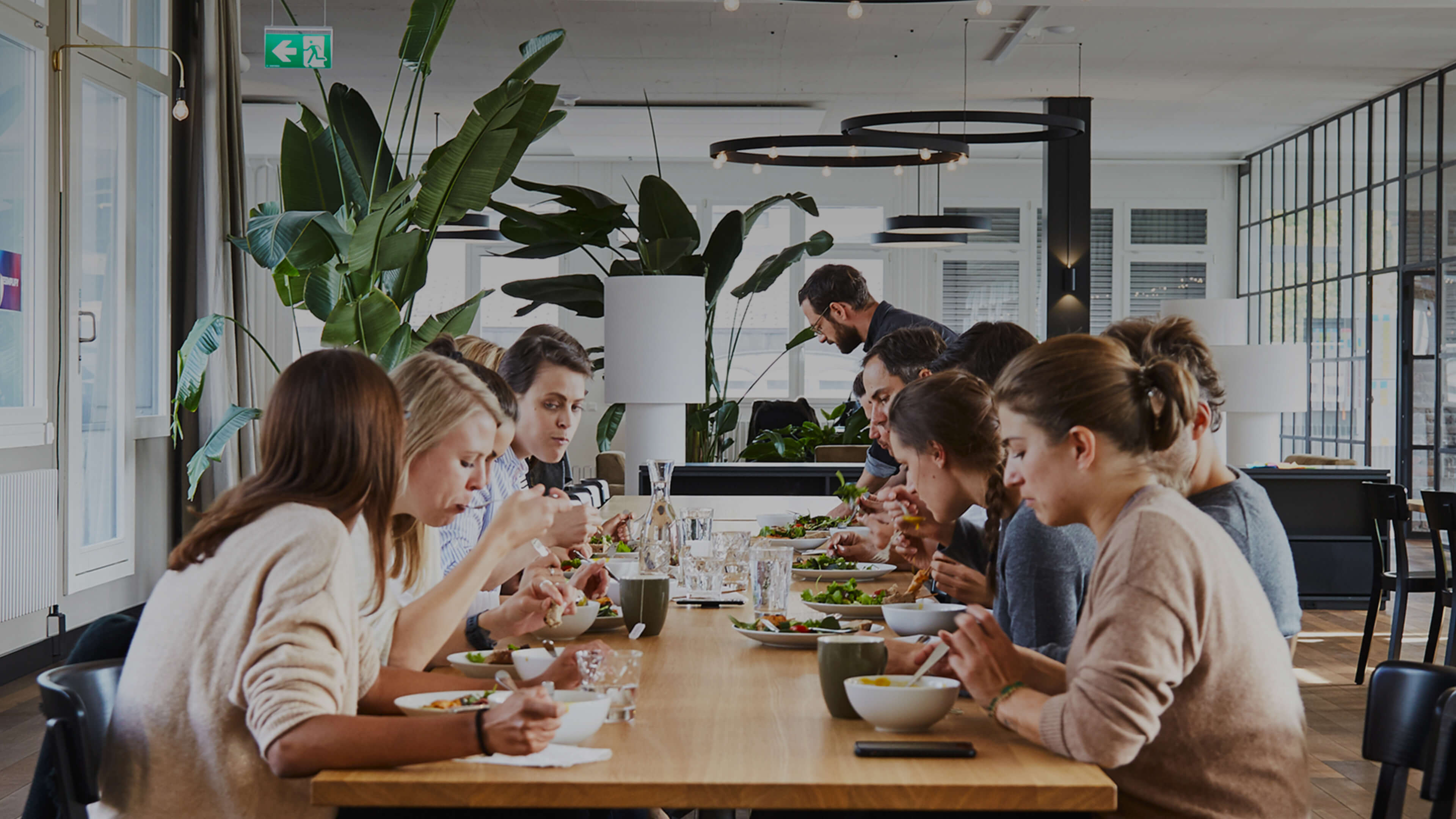 A group of people sitting around a table eating food.