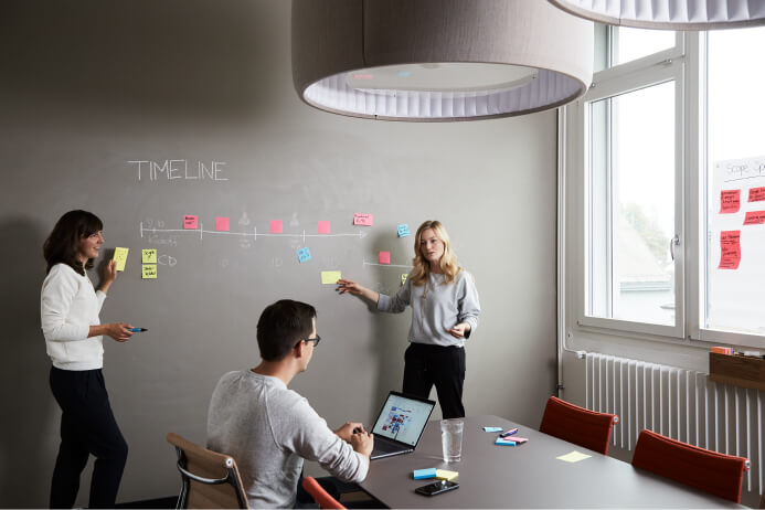A group of people writing on a whiteboard.