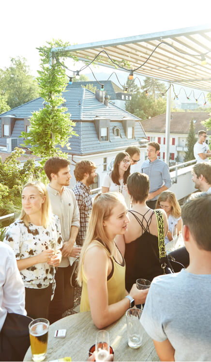 A group of people standing around a wooden table.